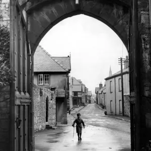 A small boy walks through the archway at the entrance of Ruthin Castle Denbighshire