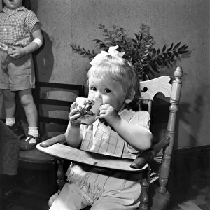 Small girl enjoying a cup of tea. August 1953 D5235