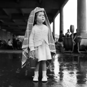A small girl sheltering from the rain at Barry Island, Vale of Glamorgan, Wales A small girl sheltering from the rain at Barry Island, Vale of Glamorgan, Wales