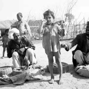 Snake charmer with his son in the market at Poonah. April 1959
