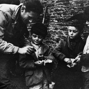 Soldado estadounidense compartiendo chocolate con los niños locales de Slapton durante la evacuación. Soldado estadounidense compartiendo chocolate con los niños locales de Slapton durante la evacuación.