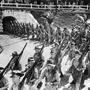 Soldiers of the Australian Imperial Force march into the parade ground in Malaya during
