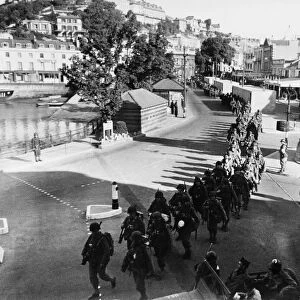 US soldiers march along the strand in Torquay. June 1944 prior to embarking on ships that