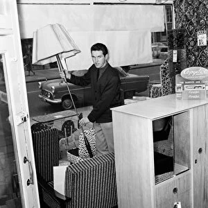 Southampton and England footballer Terry Paine at work as a furniture salesman