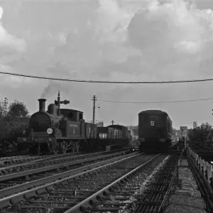 Southern Railways goods train passes a three carriage Electric Multiple Unit train on a Southern Railways goods train passes a three carriage Electric Multiple Unit train on a