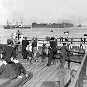 Spectators watch from the banks of the River Tyne as the hull of the Former Crack liner