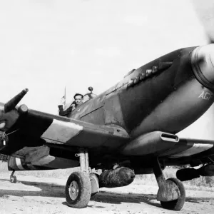 Un avión de combate Spitfire IX equipado con tres bombas listo para despegar en Normandía.