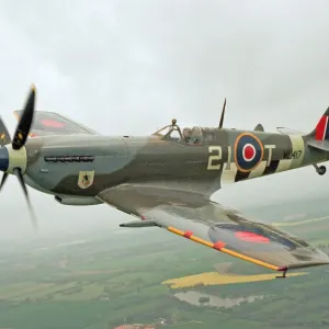 Print of a Spitfire Mk IXe in flight above Duxford, Cambridgeshire Print of a Spitfire Mk IXe in flight above Duxford, Cambridgeshire
