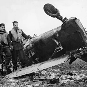 Spitfire pilots of RAF Fighter Command pose beside the wreckage of a Junkers Ju 87 Stuka