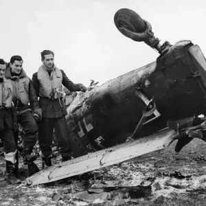 Pilotos de Spitfire del Comando de Caza de la RAF se colocan junto a los escombros de un Junkers Ju 87 Stuka.