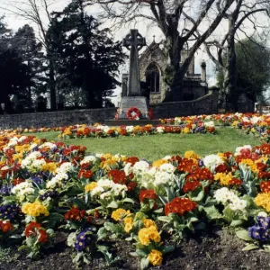 Las flores de primavera alrededor de un memorial a la guerra fuera de la iglesia San Andrés, Haughton.