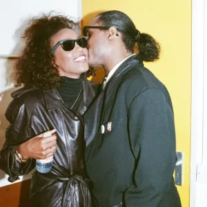 Stevie Wonder kisses Whitney Houston on the cheek as they laugh backstage at the Nelson Stevie Wonder kisses Whitney Houston on the cheek as they laugh backstage at the Nelson