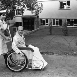 Stirling Moss, pictured in a wheelchair being pushed by a nurse