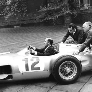 Stirling Moss sitting in his Mercedes racing car being pushed by Lord Montagu - May 1973 Stirling Moss sitting in his Mercedes racing car being pushed by Lord Montagu - May 1973