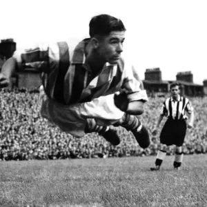 Stoke centre-half Frank Mountford diving to head away a George Robledo shot at Newcastle