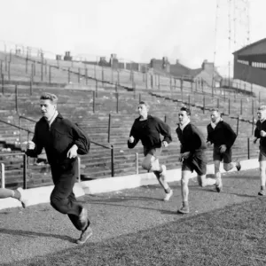 Stoke City players take part in training session, sprinting along the touch line are