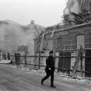 Print of a New York street scene with demolition and a policeman walking by Print of a New York street scene with demolition and a policeman walking by