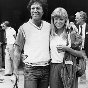 Sue Barker and Cliff Richard walking arm in arm during Wimbledon tournament - June 1983