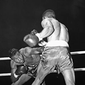 Sugar Ray Robinson ducks to avoid a blow from Randolph Turpin during their title fight at