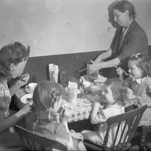 Tea time. The family gather around the kitchen table for a tea time meal. September 1946 Tea time. The family gather around the kitchen table for a tea time meal. September 1946