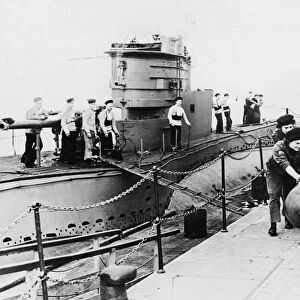 A team of five Wrens wheel a trolley carrying a 21 inch torpedo along the dockside at HMS