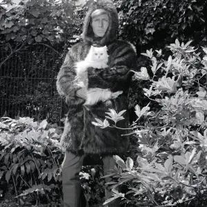 Ted Dawson modelling a fake fur coat with a hood for men while holding a white furry cat Ted Dawson modelling a fake fur coat with a hood for men while holding a white furry cat
