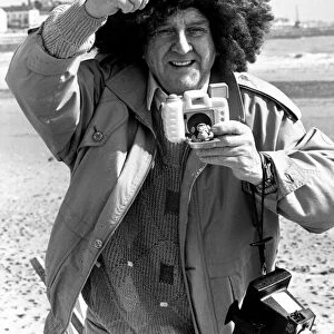 Television comedian Norman Collier wearing a funny wig on the beach April 1991