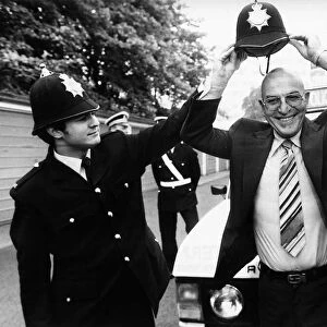 Telly Savalas Greek actor tries on police helmet, June 1980
