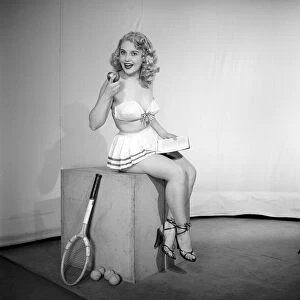 Anyone for tennis? Woman wearing bra, skirt holding tennis racket. 1959