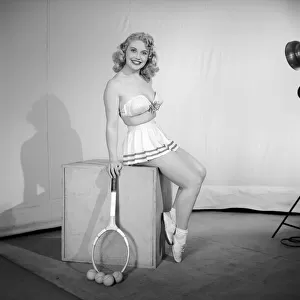 Anyone for tennis? Woman wearing bra, skirt holding tennis racket. 1959