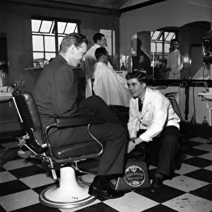 Terence O Neill at work as a shoe-shine boy in the barbers shop at the American Air