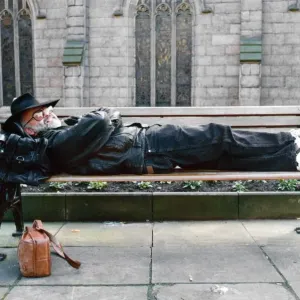 Terry Pratchett sdraiato su una panchina. Pratchett è uno scrittore inglese di romanzi fantasy.