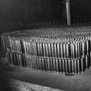 Thousands of 3. 7 inch Anti Aircraft shell cases stacked up in a munitions factory