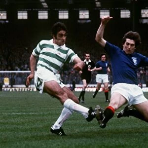 Tom Forsyth of Rangers slides in to try and block a shot by Paul Wilson of Celtic during