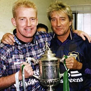 Tommy Burns Celtic football manager and singer Rod Stewart holding cup trophy at Davie