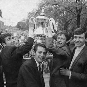 Tottenham Hotspur players celebrate with the FA Cup trophy on an open top bus parade in