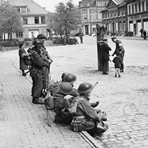 Troops of the 1st Batt. Glasgow Highlanders sitting in the streets of Verden waiting to