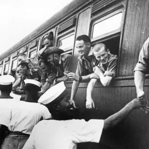 Troops of the Australian Imperial Force fraternise with the local Malaya Navy as they Troops of the Australian Imperial Force fraternise with the local Malaya Navy as they
