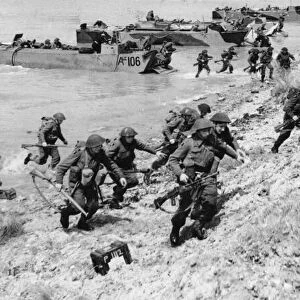 Troops coming from assault landing craft ashore during invasion exercises which a re a