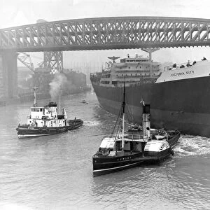 Tugs move in to take hold of the ship Victoria City after the launch at William Doxford