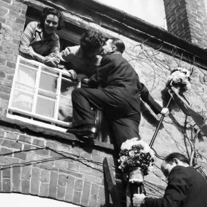 The tutti-men climb a ladder to get the traditional kiss the window during the Hock-tide