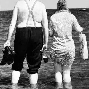 Typical Geordie couple Bill and Effie walk in the sea - Bill has his bottle of Brown Ale