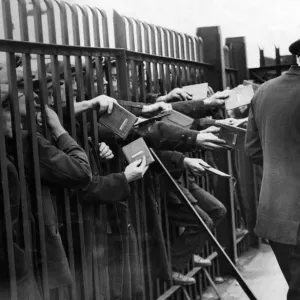 Unemployed sailors thrusting their discharge books through a landing-stage barrier Unemployed sailors thrusting their discharge books through a landing-stage barrier