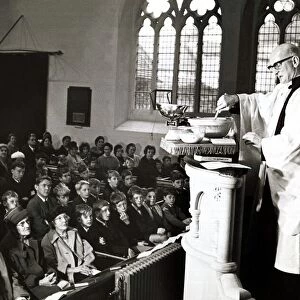 Unusual - A vicar prepares his christmas pudding at a service in church