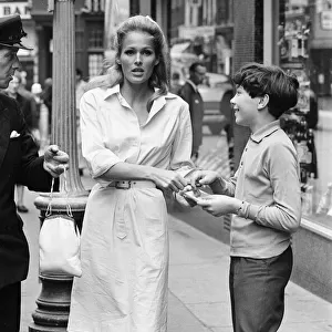 Ursula Andress, Swiss actress, signs autograph for young admirer