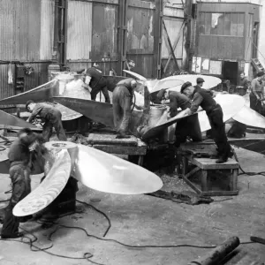 Using pneumatic chisels these workmen are seen cutting surplus metal off newly cast