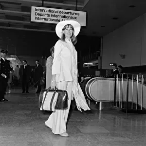 Vanessa Redgrave, wearing a beige bell-bottomed cotton trouser suit with a floppy hat to