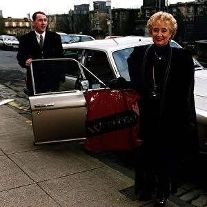 Vera Weisfeld standing beside Rolls Royce car holding plastic bag Weisfelds store