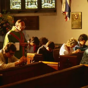 Vicar in church with people praying in Hungerford August 1987 Vicar in church with people praying in Hungerford August 1987