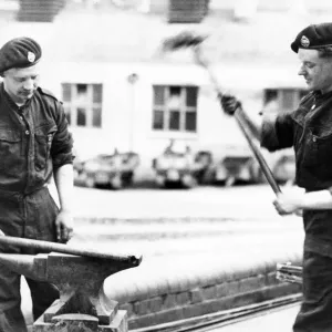 The village blacksmith in a new setting. Tank Corps members carrying out repairs on an